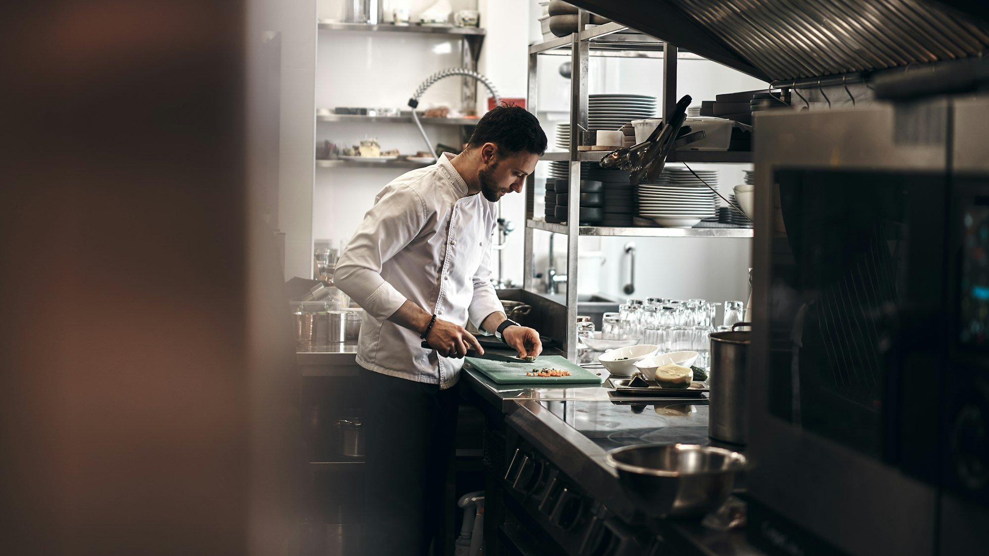Le chef prépare les légumes dans la cuisine ouverte