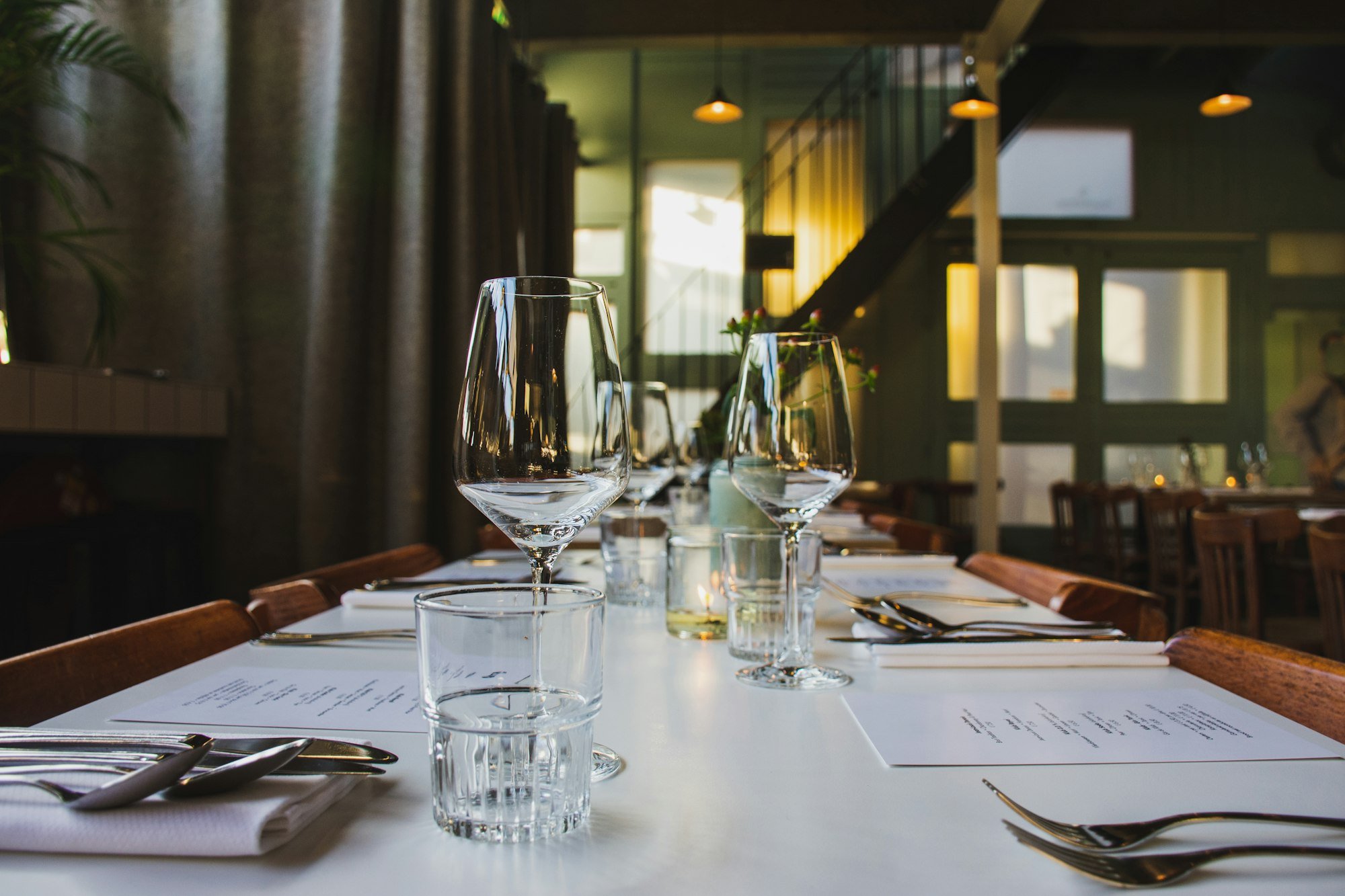 Table dressée avec des verres à vin avant le service du soir